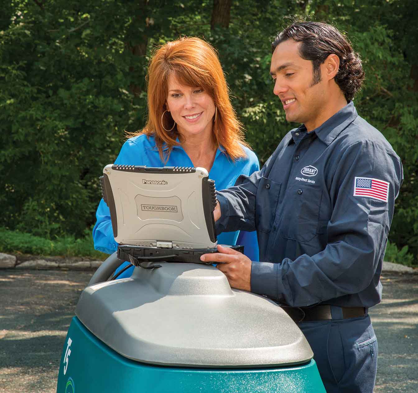 Tennant service technician talking to customer about cleaning equipment Tennant service technician talking to customer about cleaning equipment